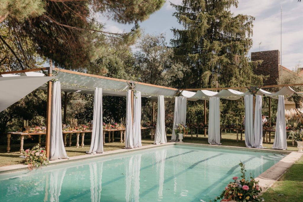 Pergolas de madera para eventos decoracion boda con cortinas elegantes alrededor de piscina para dar sombra