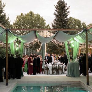 Pergolas de madera para sombra en evento alrededor de piscina con iluminacion