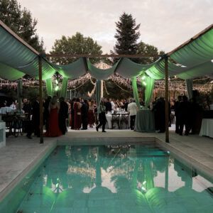 Pergolas de madera para sombra en evento alrededor de piscina con iluminacion