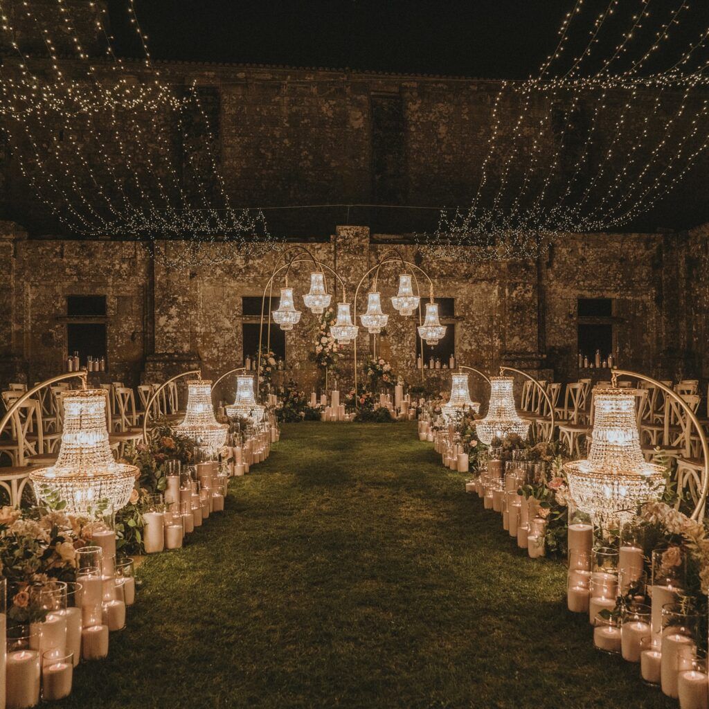 Vista detallada de lámparas chandelier clásicas de cristal colgadas a diferentes alturas en el interior de una carpa para eventos.