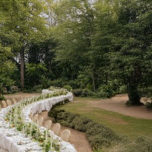 Primer plano de mesa serpenteante para boda con mantel blanco drapeado y montaje de copas de cristal.