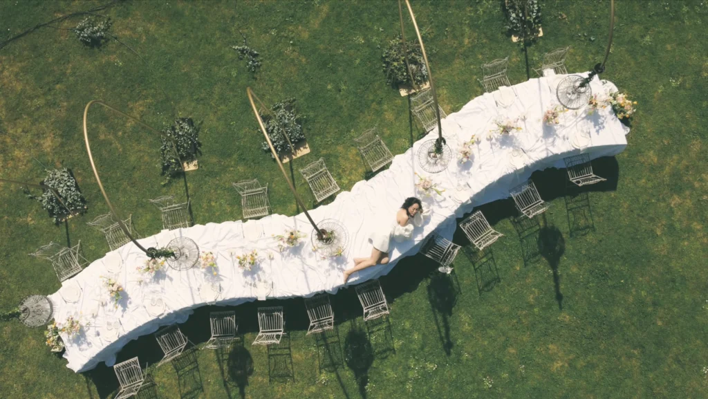 Gran montaje de banquete de boda con múltiples filas de mesas serpenteantes y mantelería drapeada en el Balneario de Guitiriz.