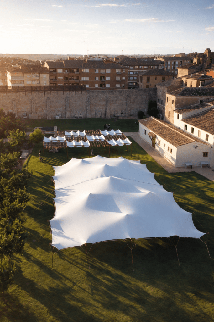 Carpa profesional para eventos instalada como arquitectura efímera en espacio histórico con estructura tensada y diseño de implantación